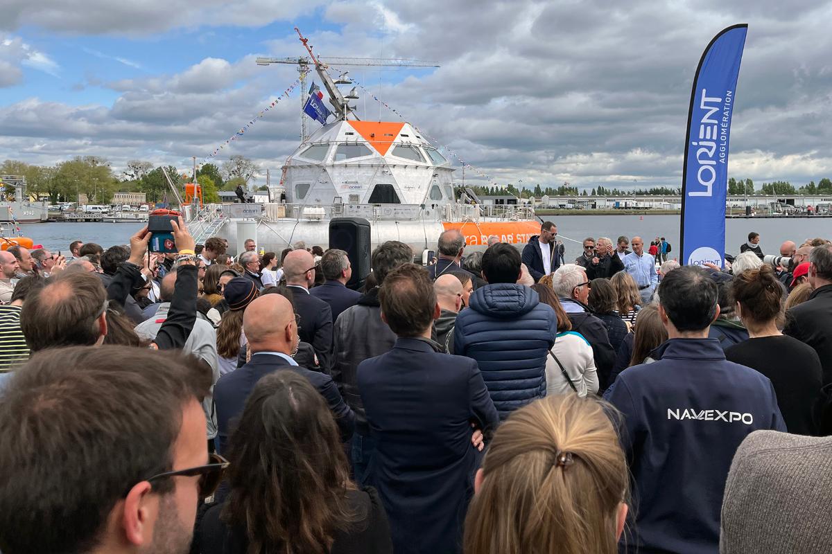 Mange på kaia.jpg Mange mennesker på en kai foran et maritimt fartøy.